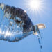 Water bottle with blue sky and bright sun