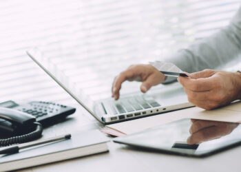 Businessman doing online banking, he is making e-payments with a credit card and his laptop, online business and finance concept