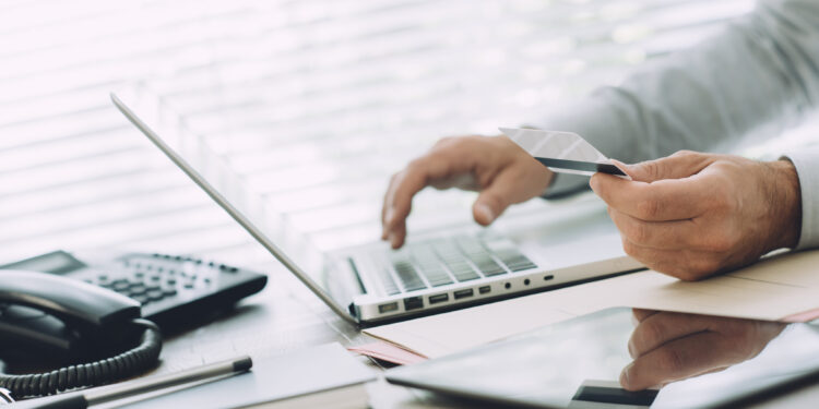 Businessman doing online banking, he is making e-payments with a credit card and his laptop, online business and finance concept