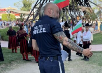 На ръката на полицая се откроява цял ръкав  с рисунки на китайски (будистки) храм - пагода, преплетен с традиционните цветове на цъфнала китайска вишна   Снимка: БГНес