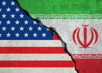 iranian flag on broken wall and half usa united states of america flag