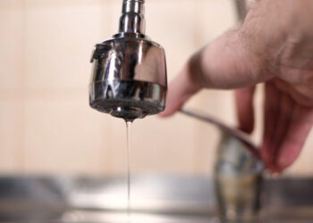 a man opens a faucet in the kitchen, but no water comes. Overlapping water, shutting off water supply. Close-up