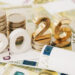 Gold Colored 2026 text and stack coin over 200 Euro Bills